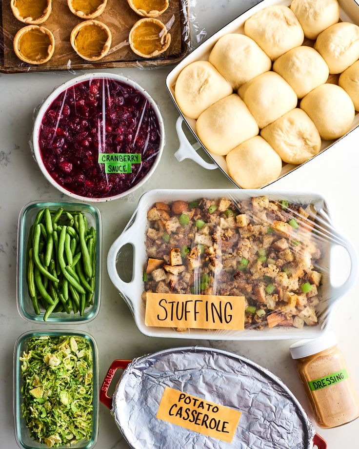 the food is prepared and ready to be cooked in the oven, including broccoli, cranberry sauce, green beans, sweet rolls, stuffing