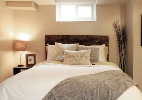 a bed with pillows and blankets on top of it next to a window in a bedroom