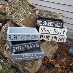 three wooden signs are stacked on top of each other in front of a house that has been cut down