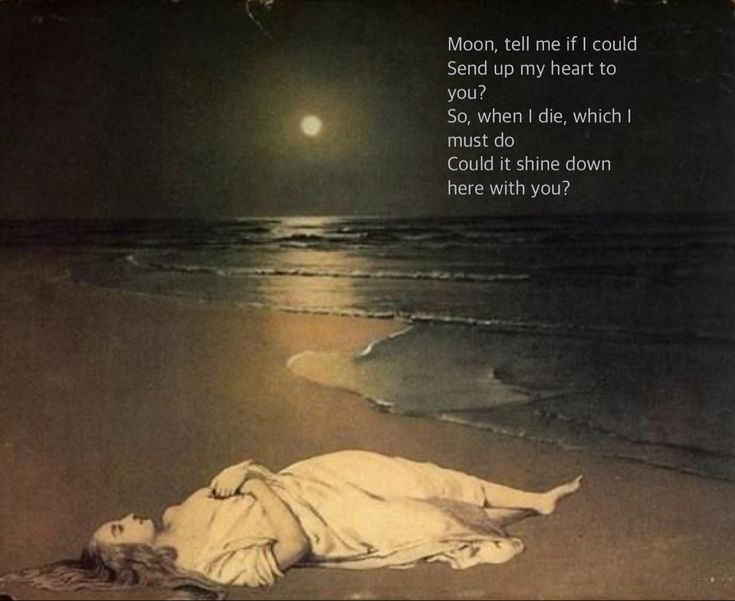 a woman laying on the beach under a full moon with her head in the sand