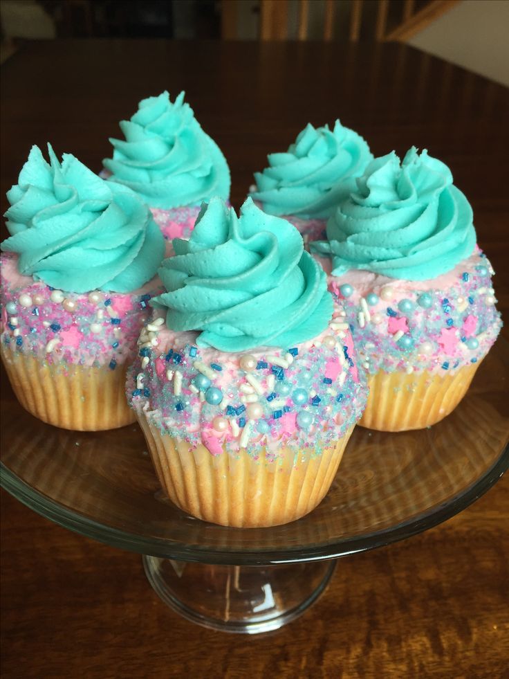 cupcakes with blue frosting and sprinkles on a glass plate