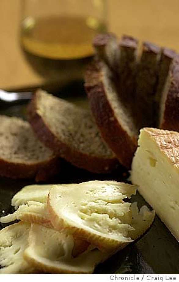 slices of bread and butter on a plate with a glass of wine in the background