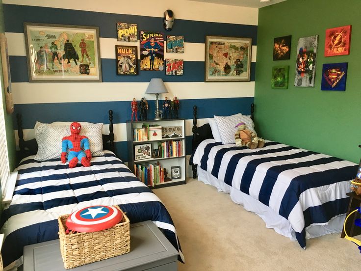 two beds in a room with green walls and pictures on the wall above them are children's toys