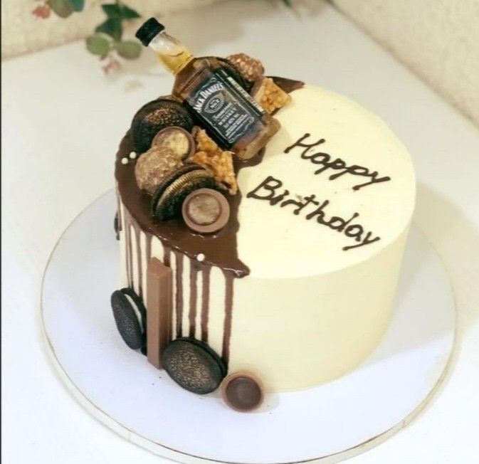 a birthday cake decorated with wine bottles and corks on a white tablecloth next to a potted plant