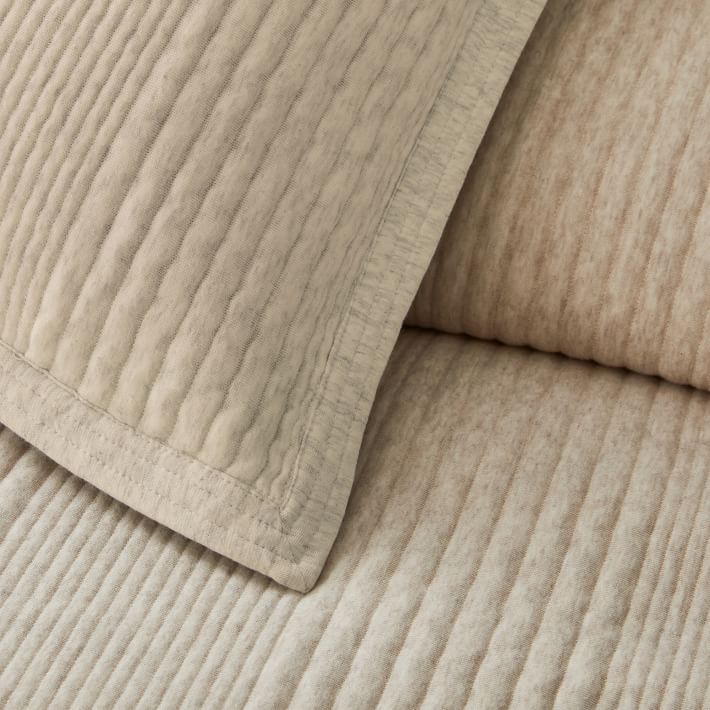 closeup of two pillows on top of each other, one is white and the other is beige