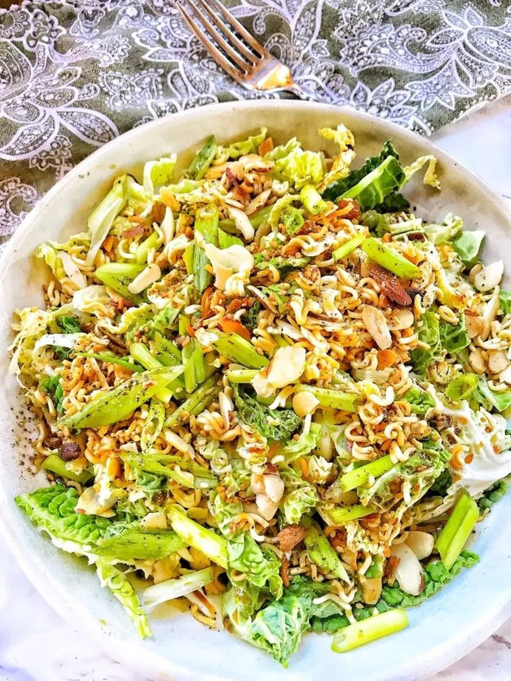 a white bowl filled with broccoli and nuts on top of a lace table cloth