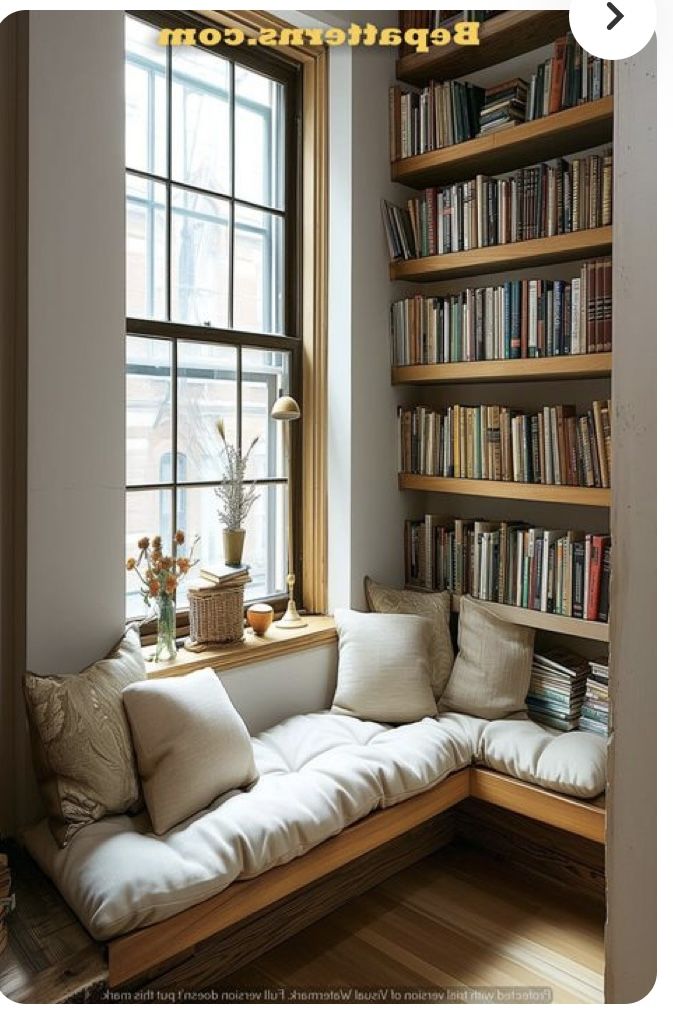 a window seat in front of a bookshelf filled with books