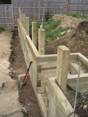 a wooden fence that is being built in the dirt