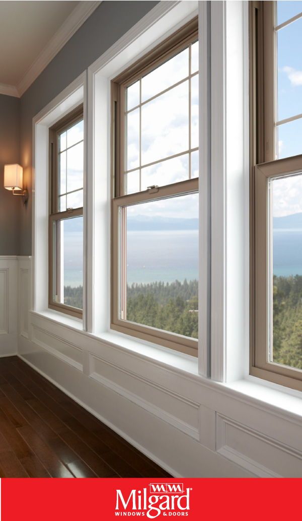 three windows in a room with wood floors and white trim on the walls, along with an ocean view