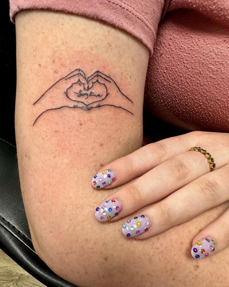 a woman's legs with polka dot nail polishes and a tattoo on her arm