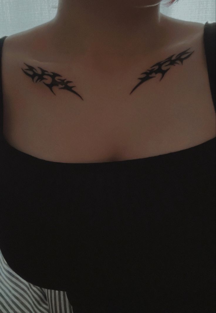 a woman's chest with two black birds on it