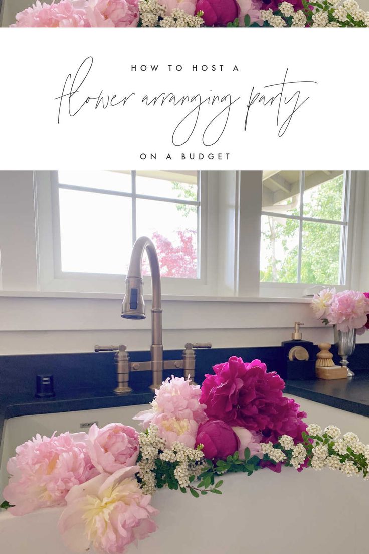 pink and white flowers are sitting on the kitchen sink