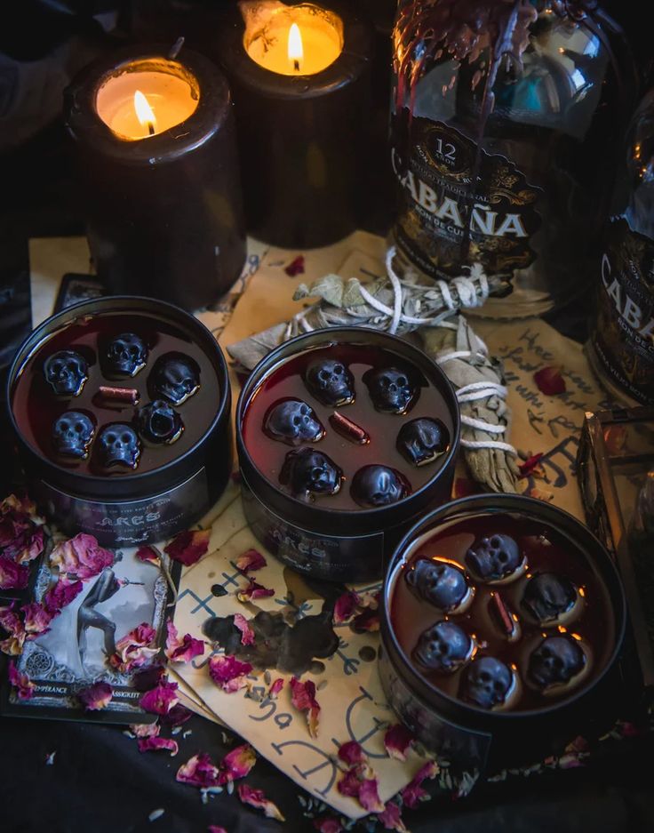 three candles sitting on top of a table next to some bottles and paper with writing