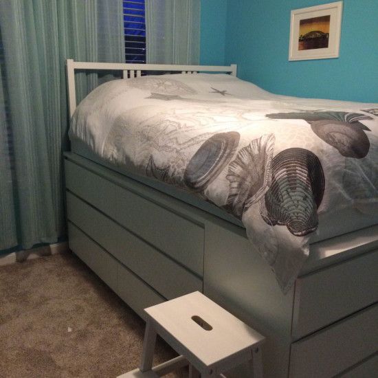 a bedroom with a bed and dresser in it