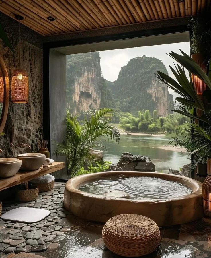 a spa room with a large stone bathtub and mountains in the backgroud