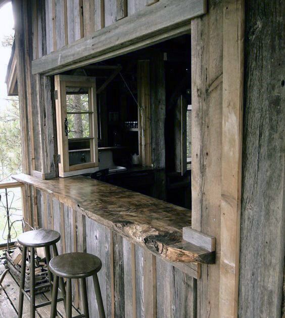 two stools are sitting at the bar in front of an old wooden building with windows