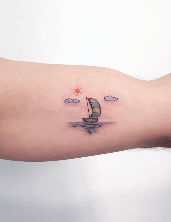 a person's arm with a small sailboat tattoo on it