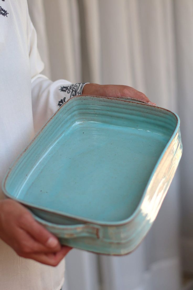 a person holding a blue dish in their hand