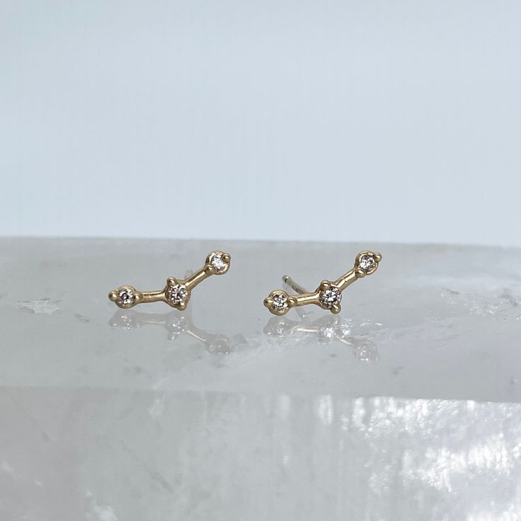 Three Round Cut Diamond 14k gold Stud Earrings made to resemble Orion's Belt. Can be made with yellow gold or rose gold.  * Metal: 14k Yellow Gold, 14k Rose Gold * Gemstone: Diamond * Stone Cut: Round * Number of stones: 3 * Setting Type: Bezel * Closure: Push Back Ready to ship in 6 weeks! All of our pieces are handmade and made to order. Message for questions about customization, including alternate gemstone or metal requests. 14k Yellow Gold Pierced Diamond Earrings, 14k White Gold Ear Climbers, 14k Gold Ear Climbers As Gift, Gold 14k Diamond Earrings Gift, Celestial Diamond Earrings As Gift, 14k Gold Ear Climbers For Gift, 14k Yellow Gold Diamond Earrings, Tarnish Resistant, 14k Rose Gold Pierced Earrings, Yellow Gold Ear Climbers In Fine Jewelry Style