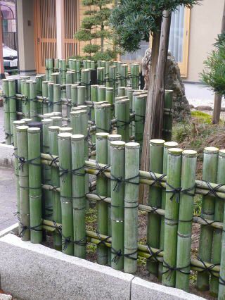 a bunch of bamboo poles that are next to each other on the sidewalk in front of a building