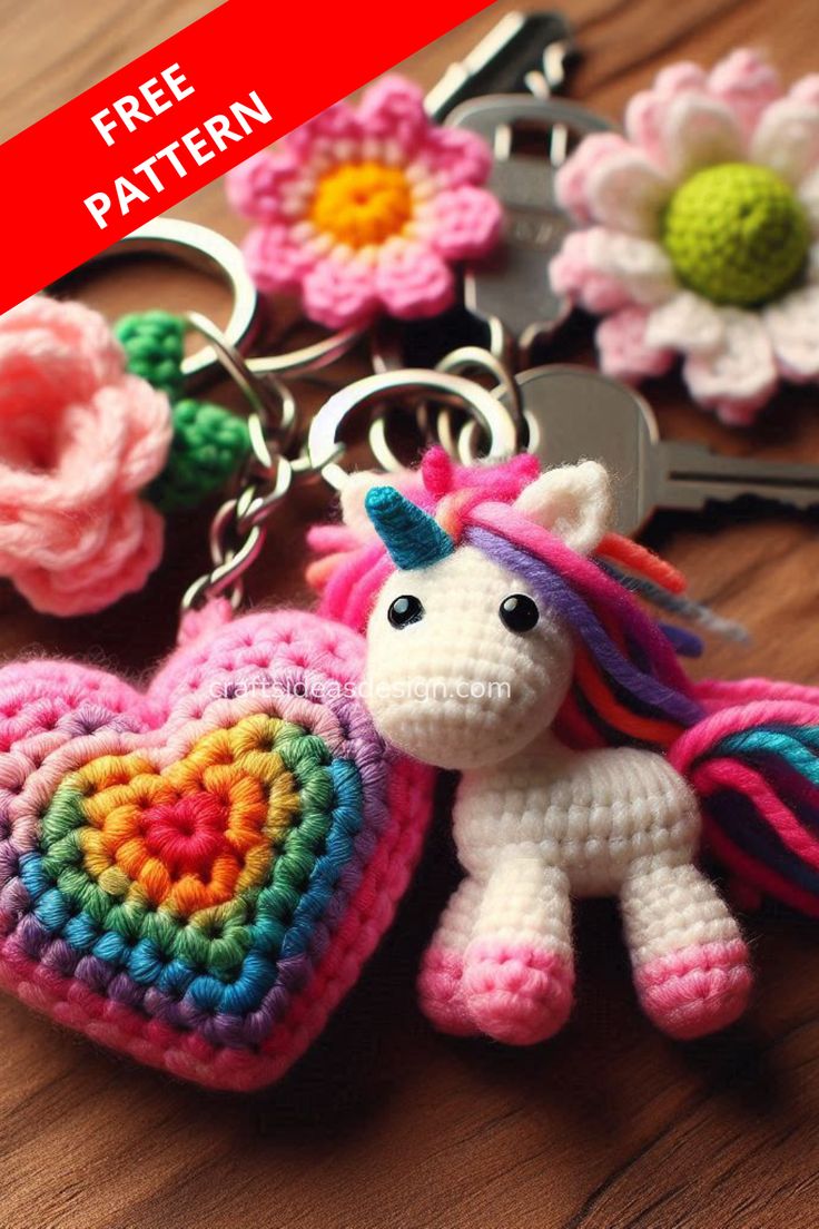 crocheted keychain shaped like a heart with a unicorn on it and flowers in the background