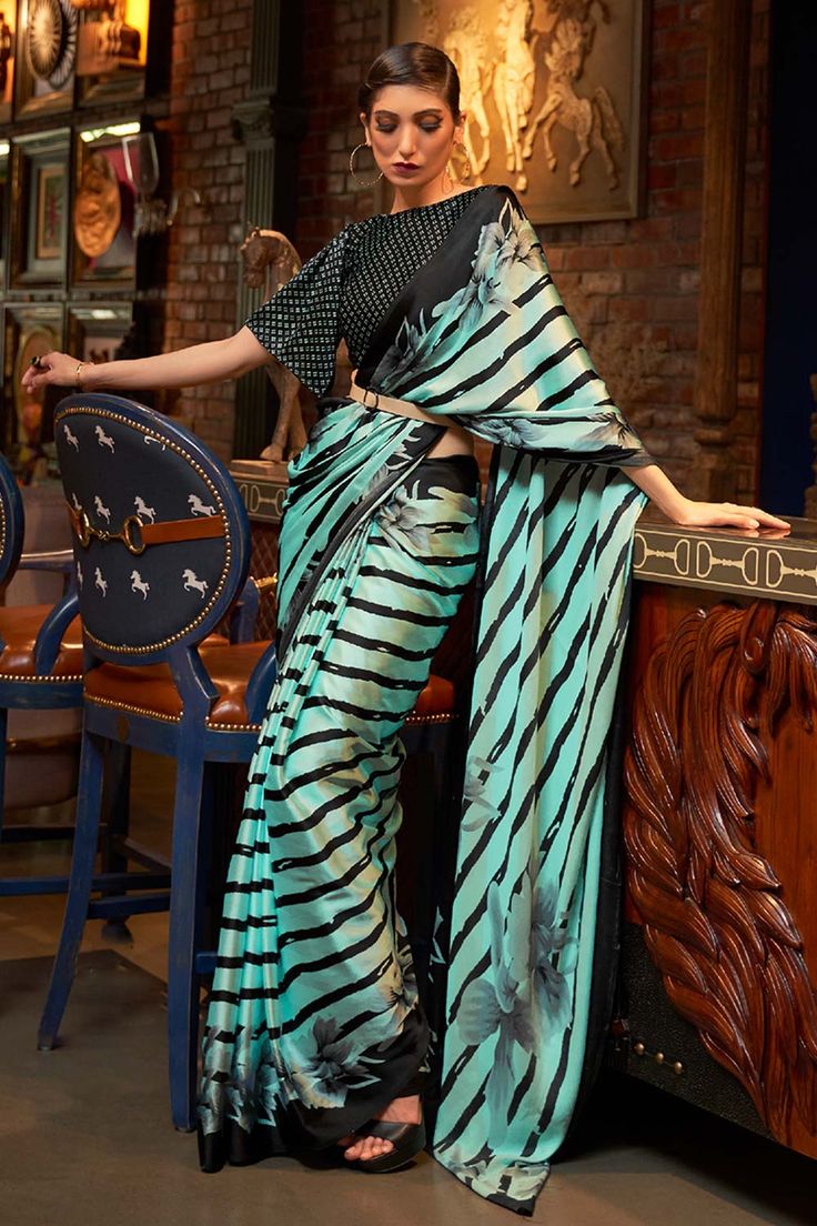 About this Product Saree: Saree Color: Turquoise Saree Fabric: Satin Type of Work: Printed Drape Style: Choose the drape style while order: Standard Open, Pleated or Gujarati Saree length: 5.5 meters Petticoat: Saree comes with an in-built butter crepe petticoat, no additional petticoat is required to wear with the saree. Sizing: Waist is adjustable +/- 1 size with a partial elastic waist band that falls under the drape for added comfort. Blouse: Optional Blouse: Blouse Style: Please customize y Crepe Silk Sarees, Crepe Saree, Party Sarees, Party Wear Saree, Satin Saree, Casual Saree, Blue Saree, Trendy Sarees, Wear Saree