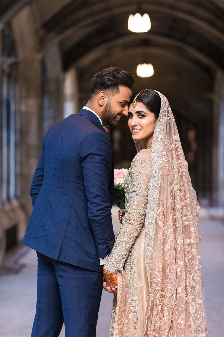 a bride and groom standing together in an old building