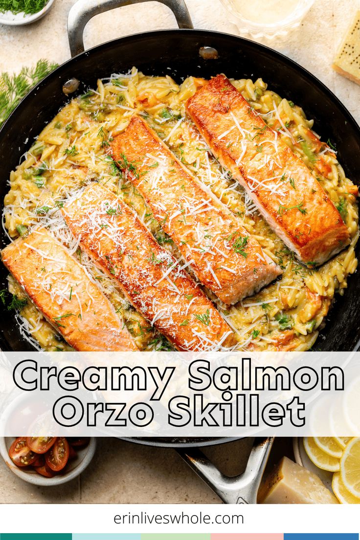 creamy salmon orzo skillet with parmesan cheese on top and lemon wedges