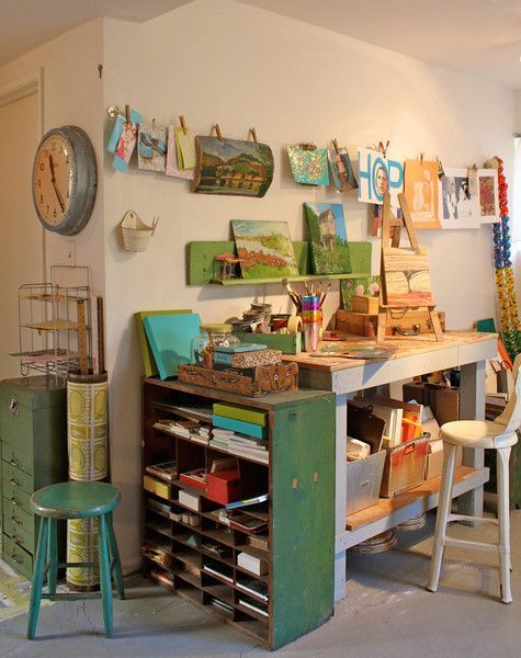 a room with many items on the wall and some chairs in front of an open desk