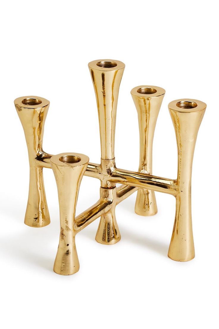 four gold candlesticks are arranged on a white background