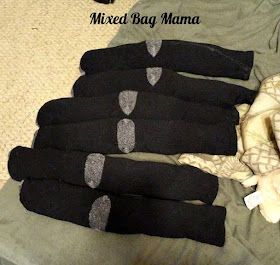 five pairs of black socks with silver hearts on them sitting next to a stuffed animal