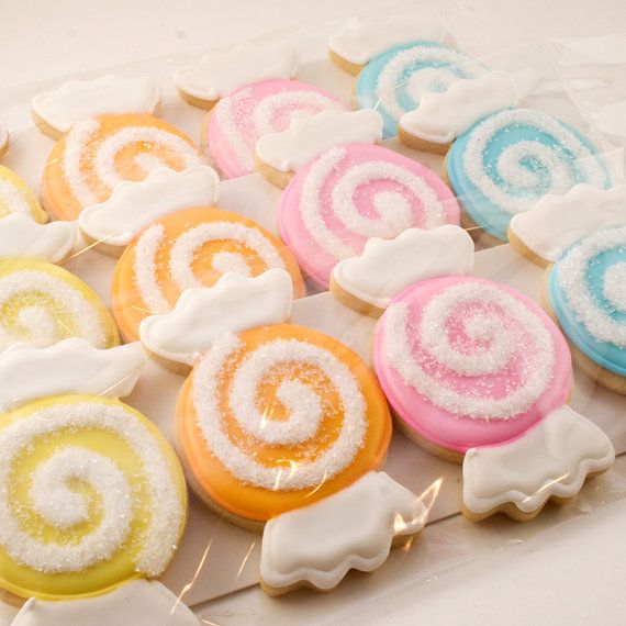 colorful cookies with icing and powdered sugar arranged on a white tablecloth background