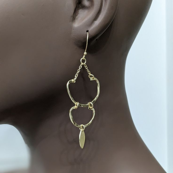 The stunning Amu Earrings! These elegant and lightweight dangle earrings feature a chic hook design made from high-quality brass metal and finished with a beautiful platino goldtone. You'll feel confident and stylish wearing these versatile earrings for any occasion. Don't sacrifice comfort for fashion - make a statement with the Amu Earrings today! Dangle style hook earrings Brass metal Platino goldtone Chic and elegant Lightweight Weight 6 grams Length 3.07 inches Handcrafted artisan radiant b Chic Gold-tone Metal Earrings, Trendy Gold Metal Earrings, Trendy Gold-tone Jewelry With Matching Earrings, Trendy Yellow Gold Metal Earrings, Gold Plated Silver Teardrop Earrings, Silver Gold-plated Teardrop Earrings, Formal Metal Drop Wrap Earrings, Chic Pierced Metal Hoop Earrings, Trendy Gold-tone Pierced Earrings