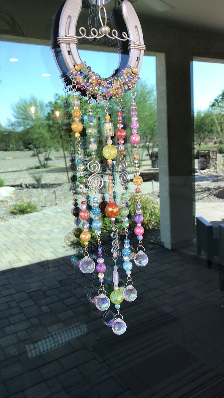 a wind chime hanging from the side of a building in front of a window