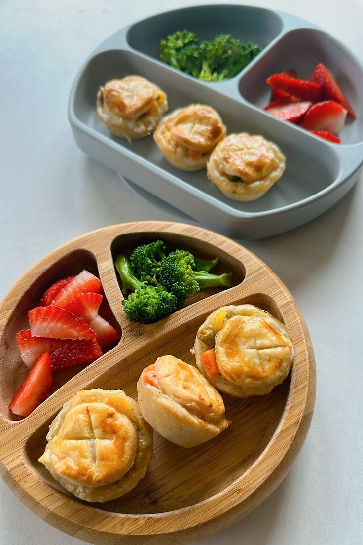 two trays filled with food on top of a table