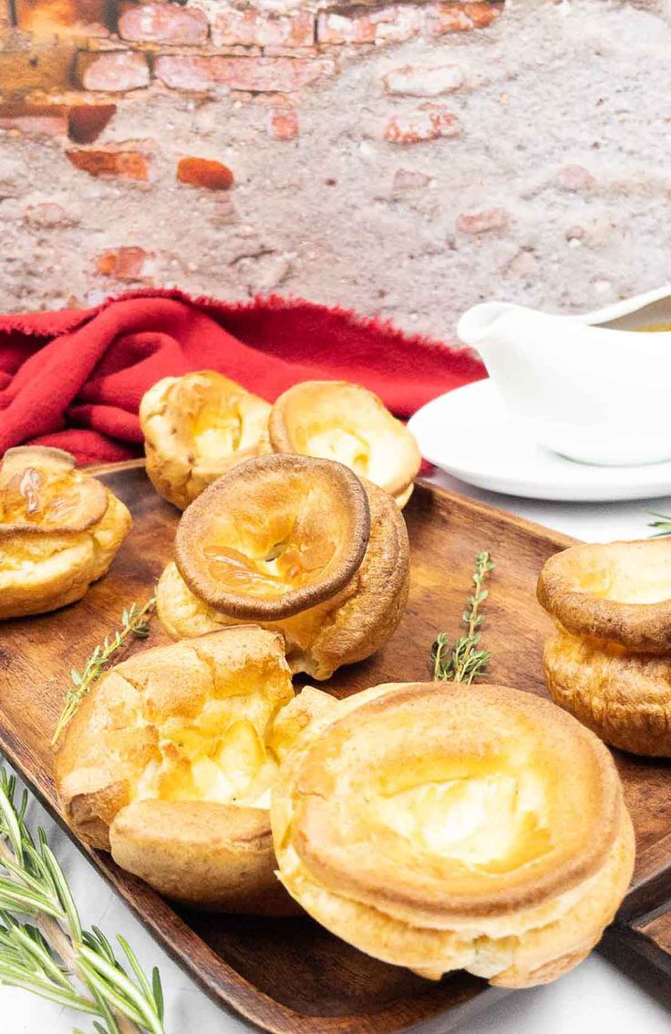 some food is sitting on a wooden platter next to a cup and saucer