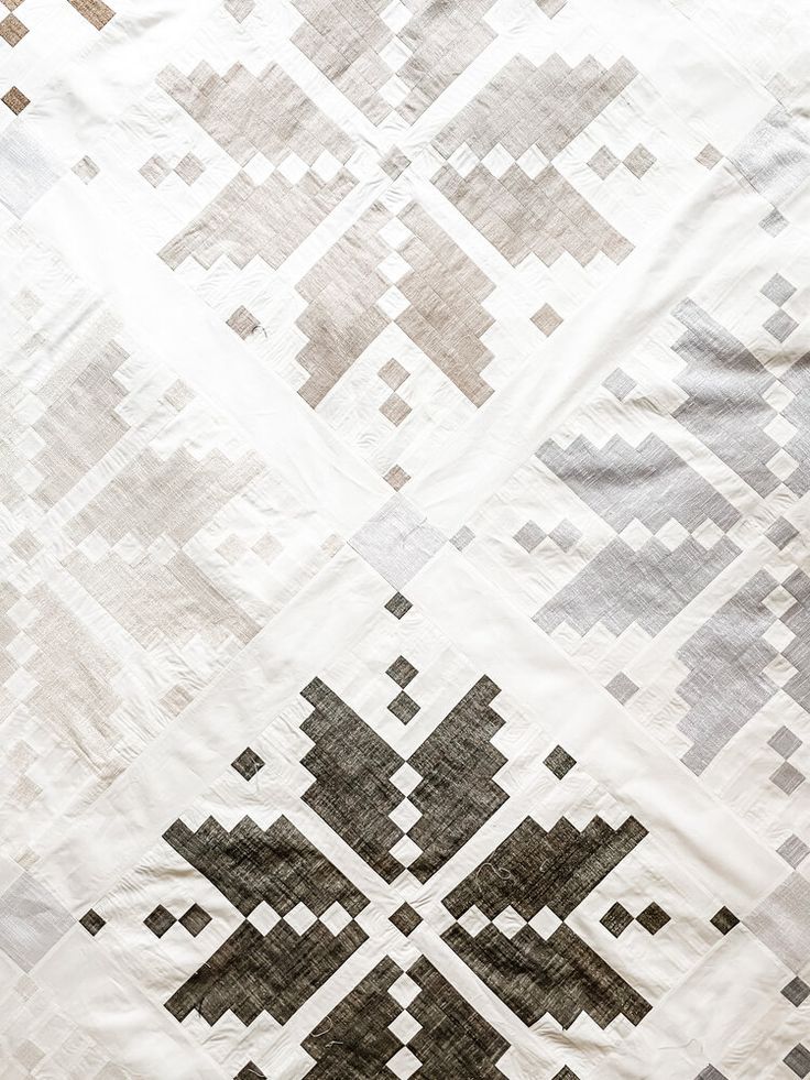 a white quilt with black and grey designs on it