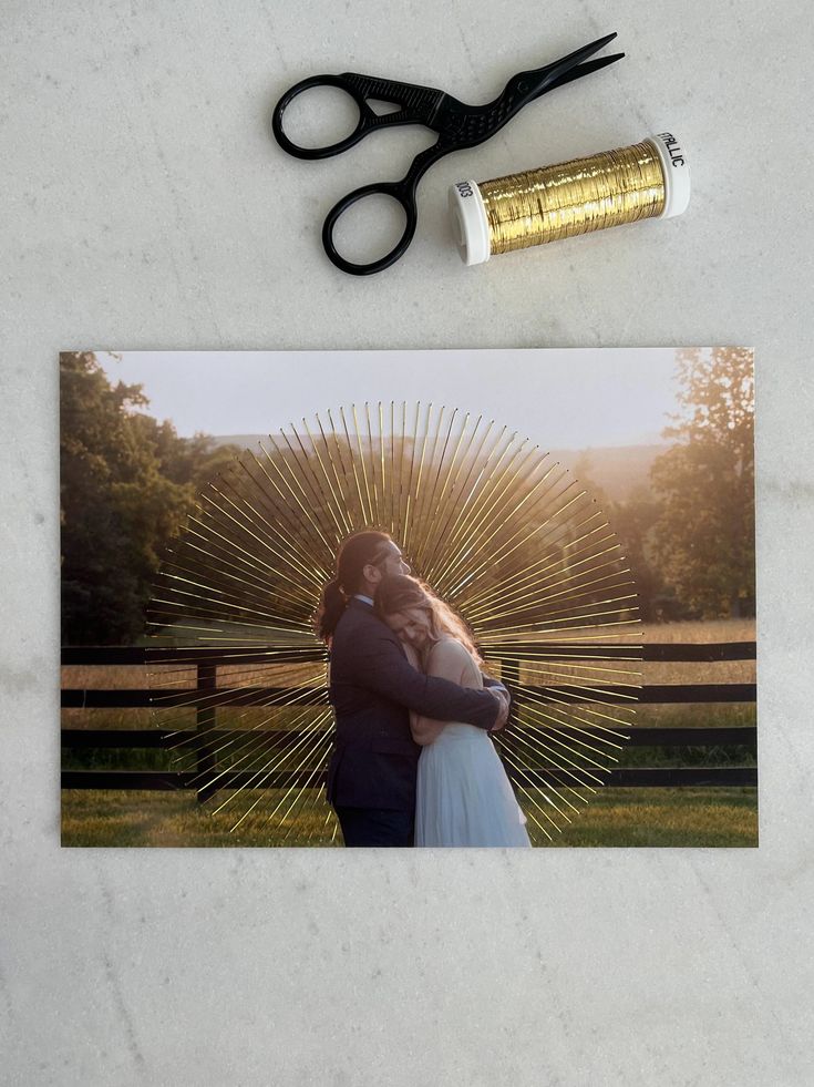 a couple kissing in front of a fence with a pair of scissors next to it