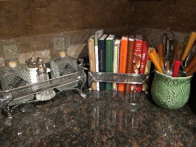 there are many books and utensils in the holder on the counter top next to each other