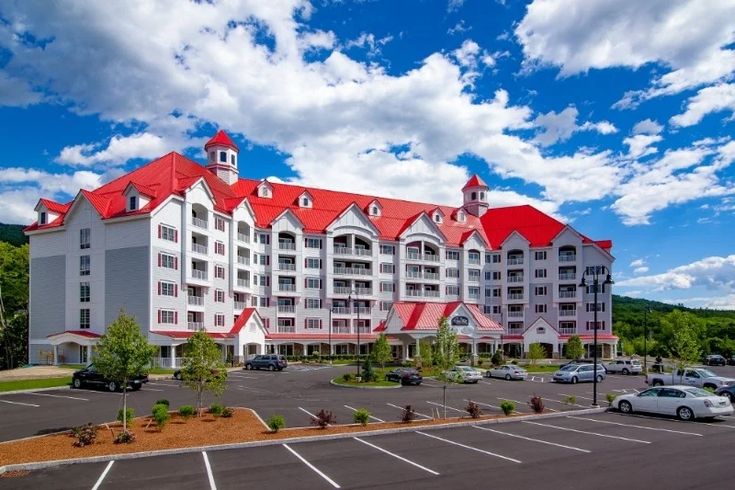 a large white and red building with cars parked in the parking lot