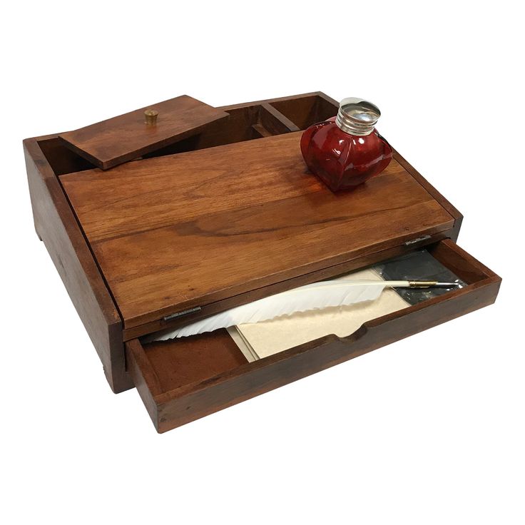 a wooden desk with a pen, paper and ink bottle in it's drawer