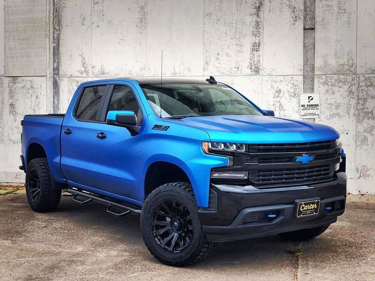 a blue truck parked in front of a building