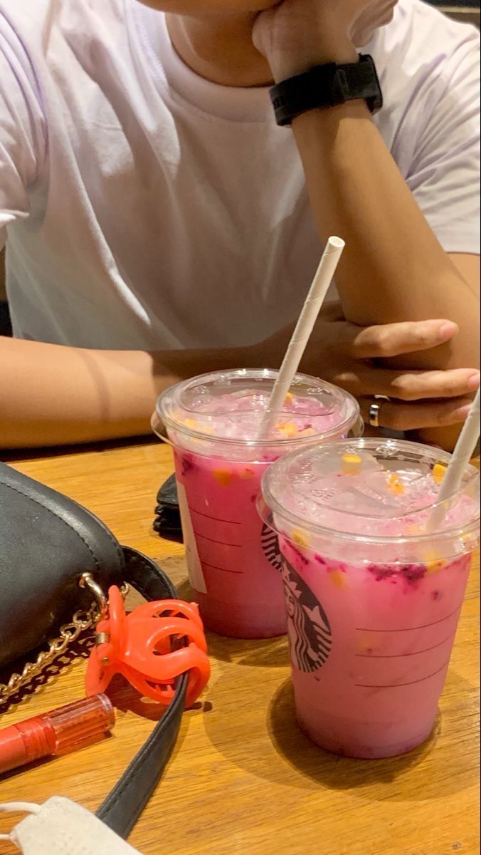 two people sitting at a table with drinks