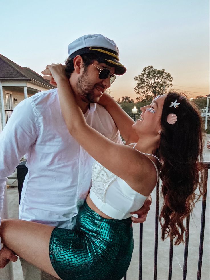 a man and woman are posing for a photo on the balcony with their arms around each other