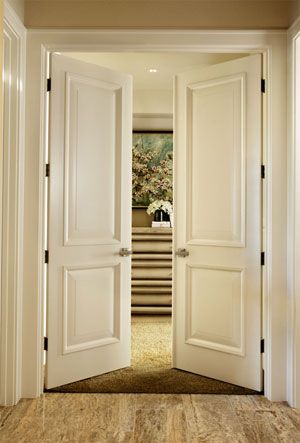 an open door leading to another room with wood floors and white trim on the walls