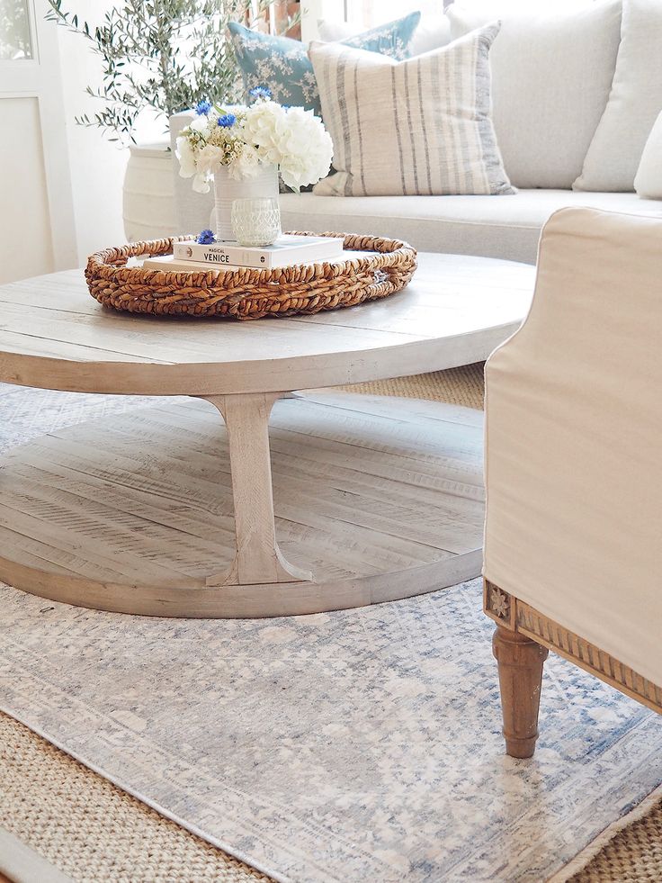 a living room with white furniture and flowers on the coffee table