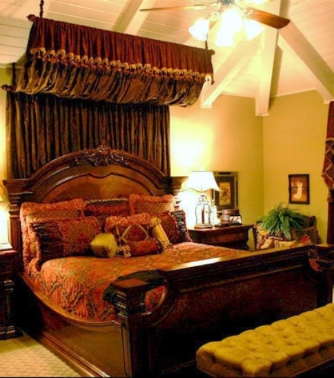 a large bed sitting under a ceiling fan in a bedroom