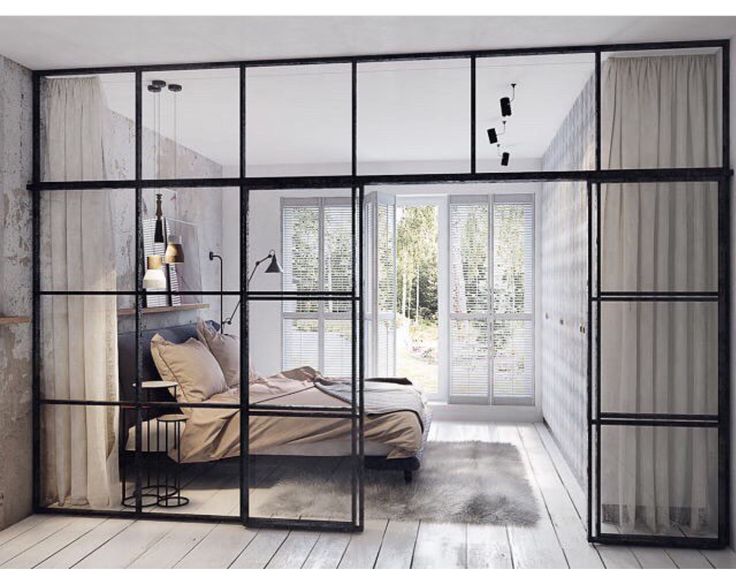 a bed sitting inside of a bedroom on top of a hard wood floor next to a window