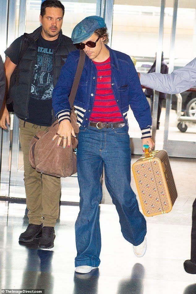 the man is carrying his luggage through the airport