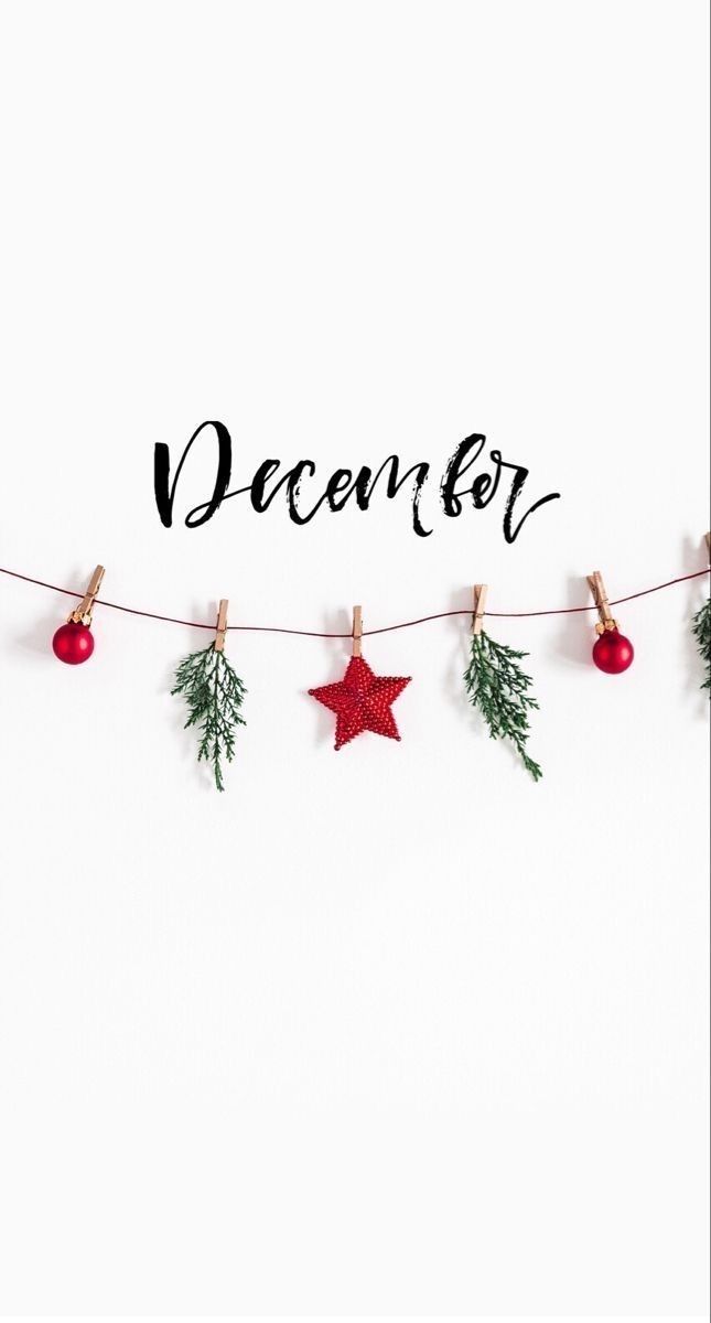 the word december is written on a white background with christmas decorations hanging from clothes pins